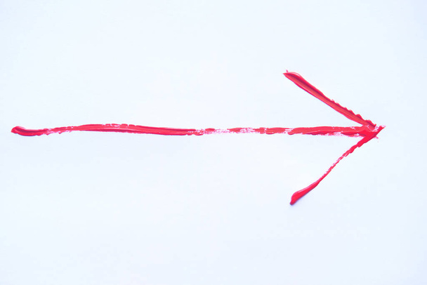 Flecha roja pintada a mano con pinceladas aisladas sobre fondo blanco
. - Foto, Imagen