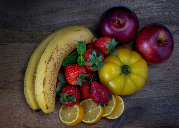 Κίτρινα και κόκκινα φρούτα σε ξύλινο τραπέζι - Φωτογραφία, εικόνα