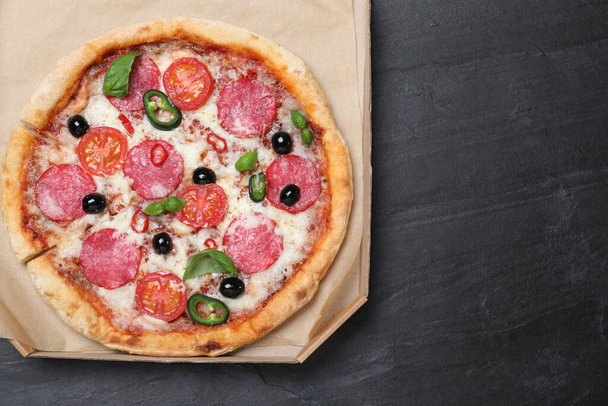Delicious pizza Diablo in cardboard box on dark background, top view. Space for text - Foto, immagini