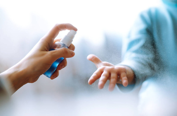 Hands with sanitizer antiseptic. Mother and child using sanitize antiseptic for hand coronavirus protection.Hygiene concept. Prevent spread of germs and bacteria and avoid infections coronavirus. - Foto, imagen