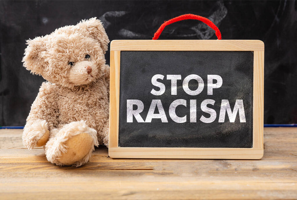 Stop Rassismus und Kids-Konzept. Teddybär und Tafel mit Stop Rassismus Text, Schultafel Hintergrund. Nein zu Rassismus für Kinder. - Foto, Bild