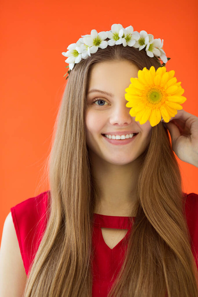 beautiful young woman with a wreath on her head with a flower in her hands - Foto, Imagen