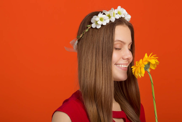 beautiful young woman with a wreath on her head with a flower in her hands - Fotoğraf, Görsel