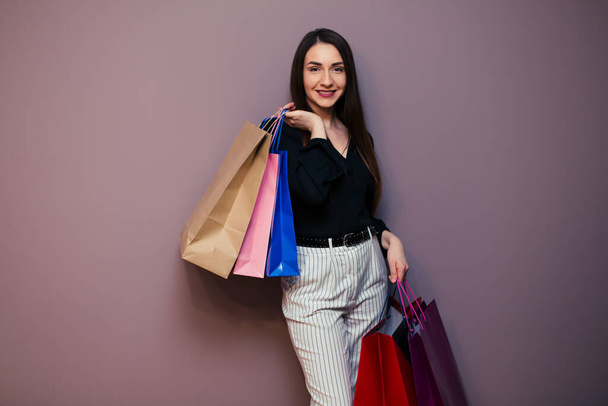 young woman goes shopping with colored packages. - Fotografie, Obrázek