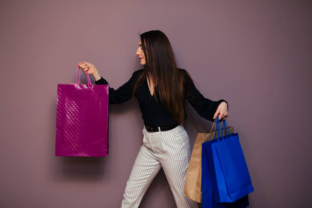 Portrait of happy brunette with paperbags after shopping. - Fotó, kép