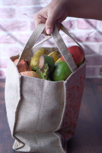 Young man holding grocery shopping bag with vegetables . - Photo, Image