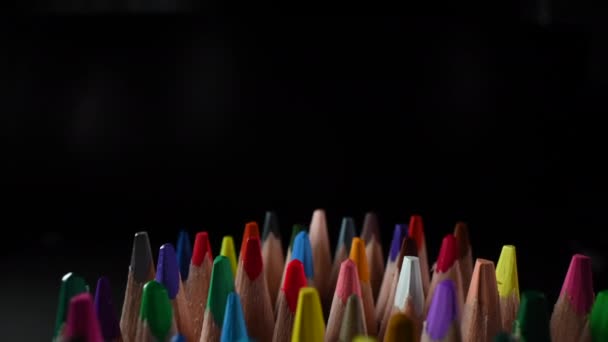 Inzoomen Over toppen van gekleurde potloden op donkere achtergrond - Video