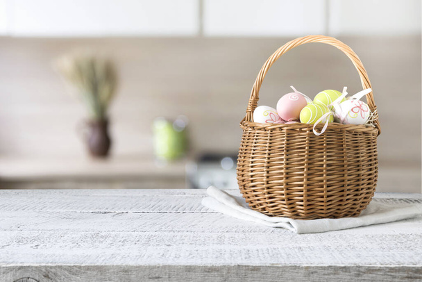 Basket with easter colorful eggs on kitchen wooden table. Spring easter composition. Space for text or design. Home holiday - Fotoğraf, Görsel