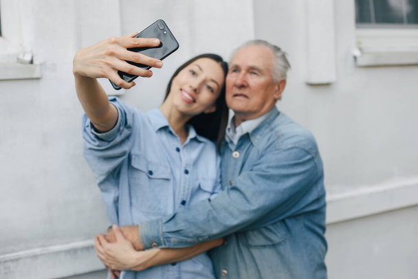 Girl teaching her grandfather how to use a phone - Foto, immagini