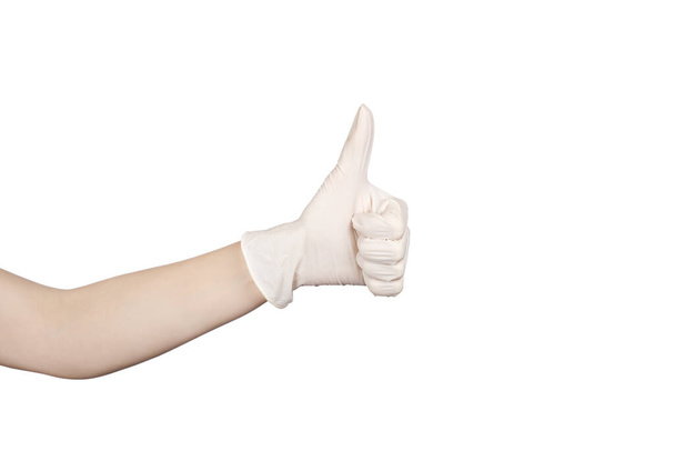 Hand showing thumbs up sign against white background. Hand in a white latex glove isolated on white. Woman's hand gesture or sign isolated on white. Copy space - Photo, Image