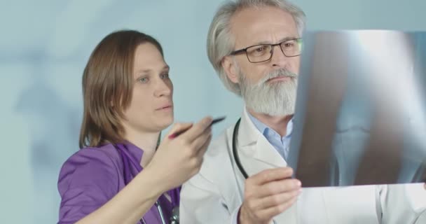 Lékař a sestra analyzují pacienty rentgenem a CT skeny v nemocnici. Střední záběr, zpomalený 4k.  - Záběry, video