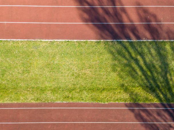 Aerial view of empty red running track. - Фото, зображення
