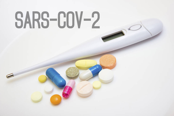 白い背景に錠剤やカプセルと電子温度計-隔離中のインフルエンザに対する保護,コロナウイルス, coid19 - 写真・画像