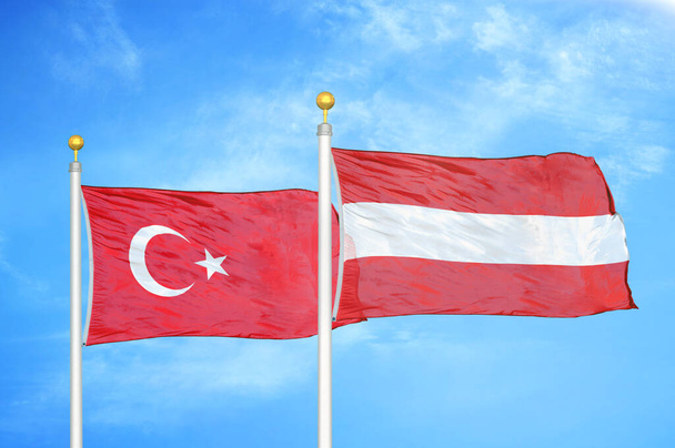Turcja i Austria dwie flagi na maszcie flagowym i niebieskie zachmurzone tło nieba - Zdjęcie, obraz