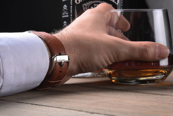 whisky a portata di mano con sfondo tavolo in legno
 - Foto, immagini