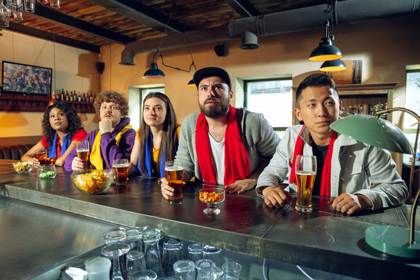 Los aficionados al deporte animando en el bar, pub y beber cerveza mientras que el campeonato, la competencia va
 - Foto, Imagen