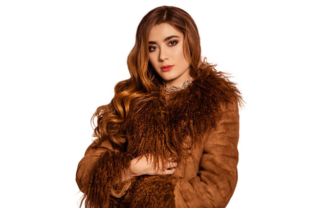 Beautiful, fashionable girl in a brown fur coat from llama fur. Luxury Winter Women. White, isolated background. - Foto, Bild