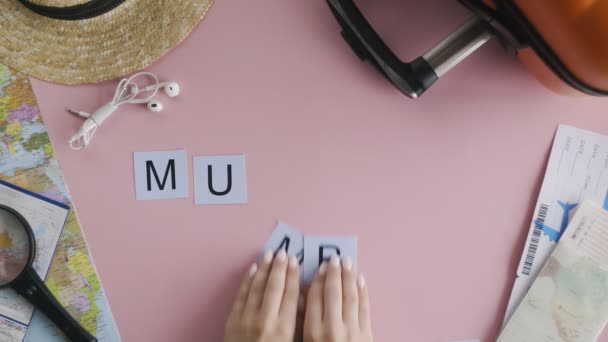 Horní pohled ruce ležící na růžovém stole slovo MUMBAI - Záběry, video