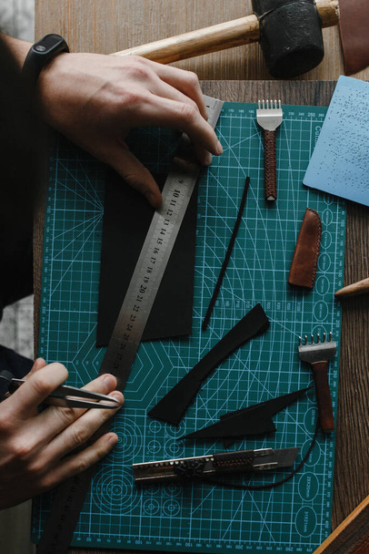 Man hands measuring shred of the leather with the ruler - 写真・画像