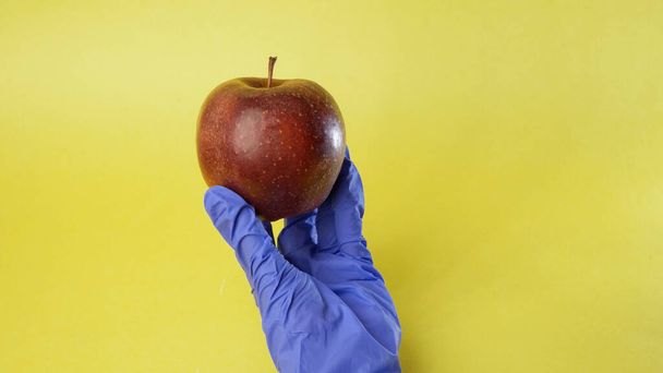Scientifique examinant une grosse pomme rouge, concept alimentaire génétiquement modifié
. - Photo, image