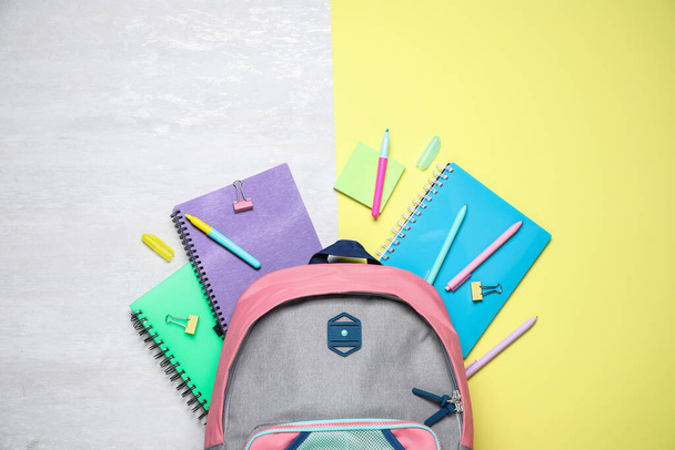 Düz kompozisyon sırt çantası ve renk arkaplanı üzerine kırtasiye - Fotoğraf, Görsel