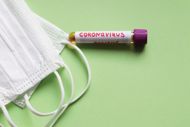 Coronavirus test tüpü ve beyaz koruyucu maskeler. - Fotoğraf, Görsel