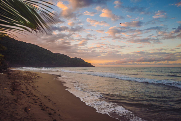 sunset in the caribbean beach with mountains and clouds - Photo, Image