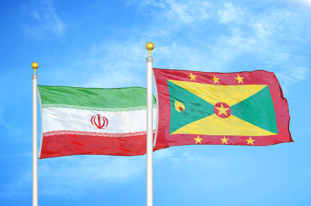 Ιράν και Γρενάδα δύο σημαίες σε κοντάρια σημαίας και μπλε θολό φόντο του ουρανού - Φωτογραφία, εικόνα