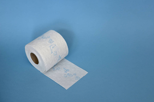 wit toiletpapier op een blauwe achtergrond - Foto, afbeelding
