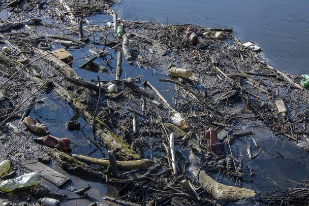 Presa de palos y escombros flotando en el río, contaminación ambiental, paisaje acuático, día soleado
. - Foto, imagen