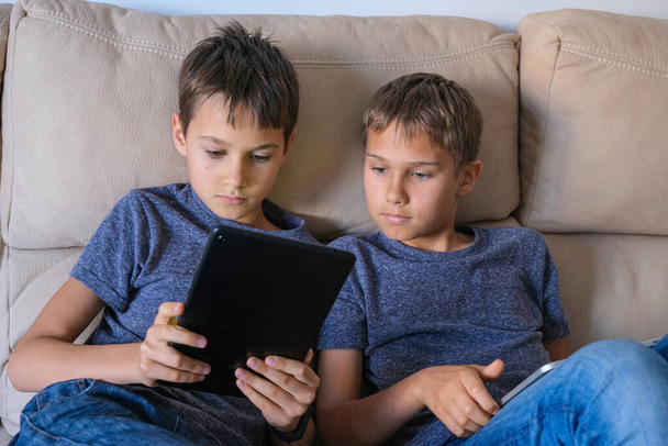 Niños usando tableta digital en casa. Tecnología, aprendizaje en línea, educación a distancia, juegos educativos para niños
 - Foto, imagen
