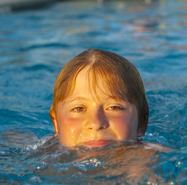 kind heeft plezier in het buitenzwembad - Foto, afbeelding