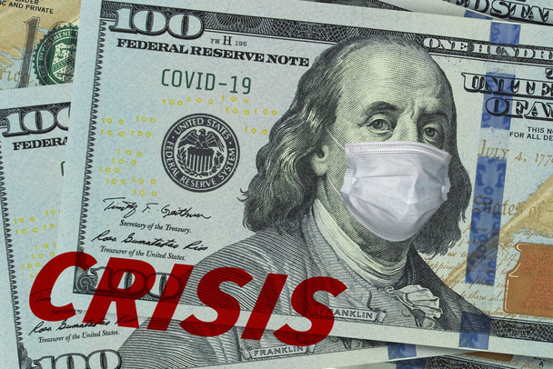 Medical mask on a banknote of 100 dollars, concept of the global financial crisis. Medical mask or surgical mask on american money. COVID-19 coronavirus in USA. Doctor mask protects against COVID-19. - Foto, Bild