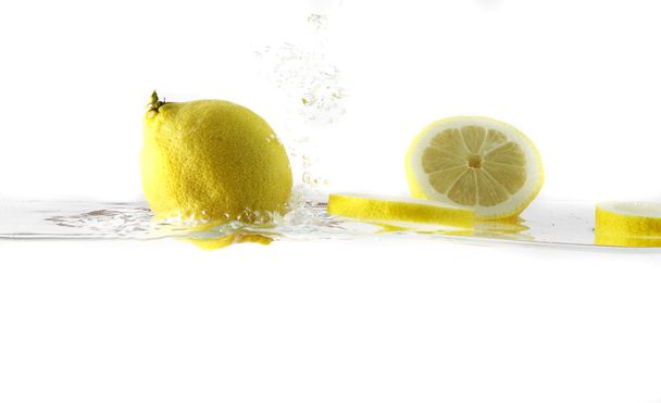 achtergrond van bubbels vormen in blauwe water nadat citroen is verbroken in het - Foto, afbeelding