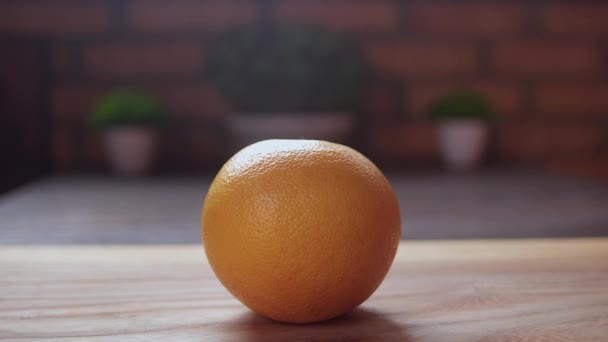 Mans hands cutting fresh grapefruit on wooden desk with knife. Healthy lifestyle concept. - Filmagem, Vídeo