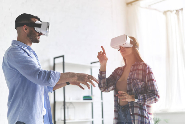 Young happy couple having fun with VR goggles headset glasses - Photo, Image