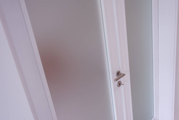 puerta de cristal doble con marco de madera blanca en el interior de la habitación vacía
 - Foto, imagen