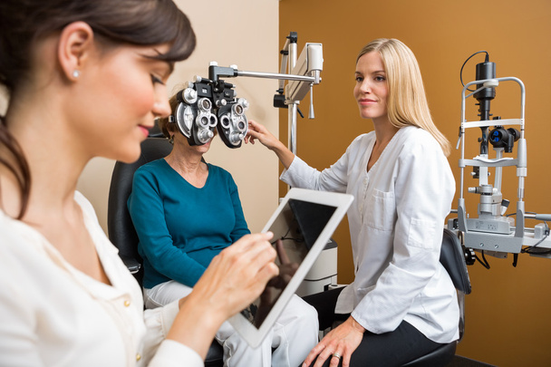 Eye Doctors Examining Senior Woman In Store - Zdjęcie, obraz