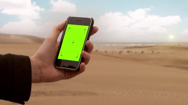 Mężczyzna Ręka za pomocą Smart Phone Green Screen na plaży. Możesz zastąpić zielony ekran filmem lub zdjęciem, które chcesz z efektem Keying w After Effects (sprawdź poradniki na YouTube).  - Materiał filmowy, wideo
