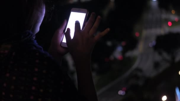 A nők közelről használják az okostelefont éjszaka.  - Felvétel, videó
