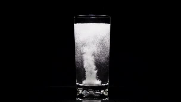 Pastillas efervescentes de primer plano aspirina en un vaso de agua sobre un fondo oscuro
. - Metraje, vídeo