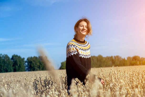 Ulkona lähikuva muotokuva nuori kaunis nainen ruskea neulottu villapaita valmistettu luonnon villaa poseeraa kentällä syksyllä puistossa. Syksyn kävely käsite
.  - Valokuva, kuva