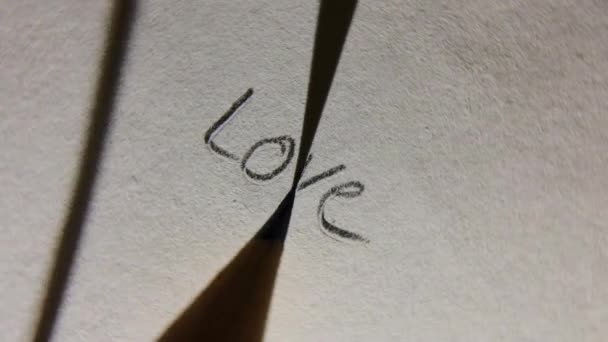 Pisanie miłości ołówkiem na papierze makro shot Obrotowe obracanie - Materiał filmowy, wideo
