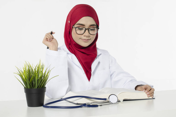 young female doctor thinking her vision and career path while sitting at her table  - Photo, Image