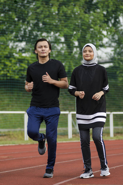 young happy couple enjoying in a healthy lifestyle, warming up and stretching before jogging - Photo, Image
