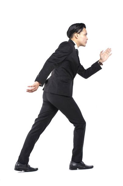 young handsome businessman standing and gesturing walking fast  over white background - Foto, Bild