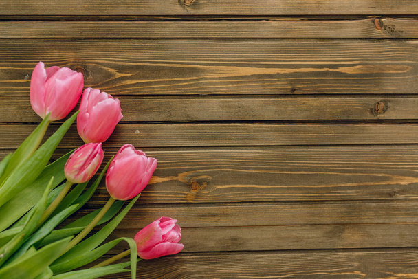 Row of tulips on wooden background with space for message. Mothers Day background. Top view - Фото, зображення