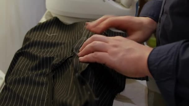 Fashion designer hands using iron. depending on the fabric, Ironing works by loosening the bonds between the long-chain polymer molecules in the fibers of the material - Záběry, video