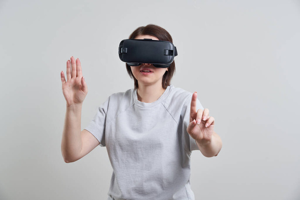 Joyeux jeune femme jouant sur les lunettes VR à l'intérieur, Concept de réalité virtuelle avec jeune fille s'amusant avec lunettes casque, avec espace de copie
 - Photo, image