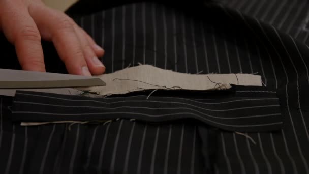 Suit designer cutting and opening the marks for tuxedo pocket. Most jackets have a variety of inner and outer pockets, which are generally either patch, flap or jetted pockets. - Footage, Video